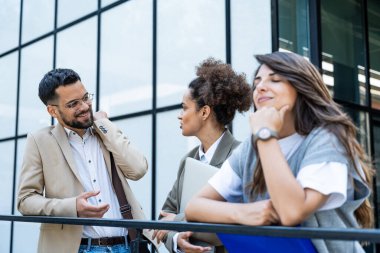 Üç genç iş adamı ofis binasının dışında bavul, dizüstü bilgisayar ve kayıt ile konuşurken birbirleriyle konuşuyorlar. Bir grup profesyonel işçi dışarıda iş ve planları tartışıyor.