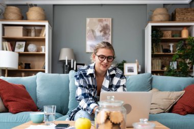 Kariyer sahibi zihniyeti. Evde çalışan serbest çalışan genç bir iş kadını. İş hayatında daha iyi fırsatlar elde etmek için kendine güvenen ve kendini eğiten, dizüstü bilgisayarda çalışan bir kadın..