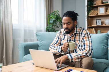 Kariyer sahibi zihniyeti. Genç serbest iş adamı evde çalışıyor. Kendini işine adamış erkek öğrenimi ve iş hayatında daha iyi fırsatlar için kendini eğitmek, dizüstü bilgisayarda çalışmak..