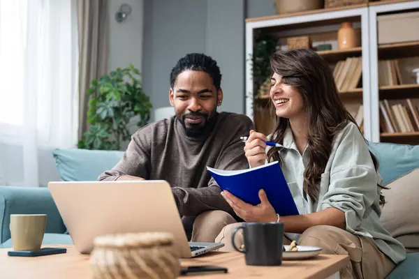 stock image Positive hipster couple having fun while working together remotely at home using modern technology, cheerful young business male and female laughing. Businesspeople in home office Independence concept