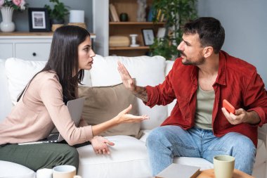 Evde oturan genç çiftin, sosyal medya ağları aracılığıyla akıllı telefonlarda sohbet ve flörtleşmenin yol açtığı kıskançlık, ilişki sorunları ve güvensizlik nedeniyle sorunları var ve tartışıyorlar.