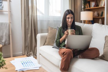 Kariyer sahibi zihniyeti. Evde çalışan serbest çalışan genç bir iş kadını. İş hayatında daha iyi fırsatlar elde etmek için kendine güvenen ve kendini eğiten, dizüstü bilgisayarda çalışan bir kadın..