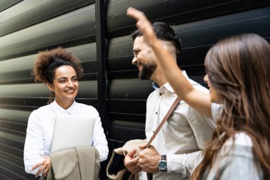 Kariyer sahibi zihniyeti. Bir grup genç iş adamı ofis binasının önünde. İşadamı ve kadınların kendilerini iş hayatında daha iyi fırsatlar için eğittiklerinden emin..