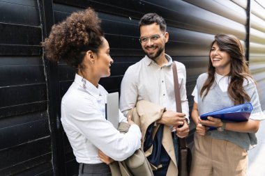 Kariyer sahibi zihniyeti. Bir grup genç iş adamı ofis binasının önünde. İşadamı ve kadınların kendilerini iş hayatında daha iyi fırsatlar için eğittiklerinden emin..
