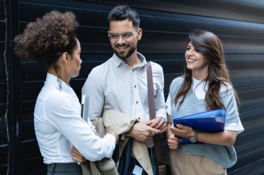 Kariyer sahibi zihniyeti. Bir grup genç iş adamı ofis binasının önünde. İşadamı ve kadınların kendilerini iş hayatında daha iyi fırsatlar için eğittiklerinden emin..