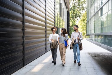 Kariyer sahibi zihniyeti. Bir grup genç iş adamı ofis binasının önünde. İşadamı ve kadınların kendilerini iş hayatında daha iyi fırsatlar için eğittiklerinden emin..