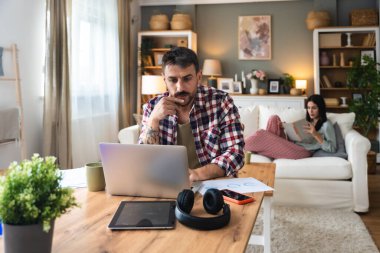 Kariyer sahibi zihniyeti. Genç serbest iş adamı evde çalışıyor. Kendine güvenen erkek öğrenimi ve iş hayatında daha iyi fırsatlar için kendini eğitmek, dizüstü bilgisayarda çalışmak..