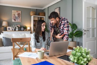 Genç bir çift, serbest çalışanlar küçük internet işletmeleri sahipleri, profesyonel tasarımcılar, bilgisayar yazılımcıları, evde birlikte çalışıyorlar, yeni bir proje üzerinde. İş adamı ve iş kadını birlikte çalışırlar..