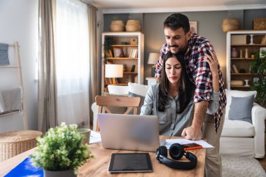 Genç bir çift, serbest çalışanlar küçük internet işletmeleri sahipleri, profesyonel tasarımcılar, bilgisayar yazılımcıları, evde birlikte çalışıyorlar, yeni bir proje üzerinde. İş adamı ve iş kadını birlikte çalışırlar..