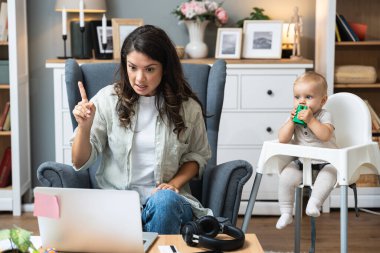 Boşanmış, çocuklu genç bir anne avukatıyla görüntülü konuşma yapmak için dizüstü bilgisayar kullanıyor. Nafaka ödemeyen eski kocasından ve küçük çocukla yaşamanın maliyetinden bahsediyor..