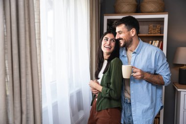 Yeni evli çiftimiz yeni evlerinin penceresinin yanında birlikte yeni hayatlarının tadını çıkarıyorlar. Nişanlı genç kadın ve erkek birlikte yaşamaya başlarlar, hayatlarının ilk günü yeni bir evde..