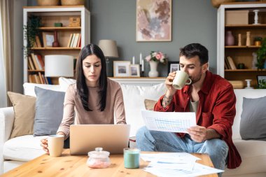 Genç iş çifti serbest çalışanlar, küçük şirket sahipleri, iş arkadaşları dizüstü bilgisayarda çalışıyor. İş adamı ve iş kadını küresel araştırma finansmanı ve fırsatları için bilgisayarı kullanıyor