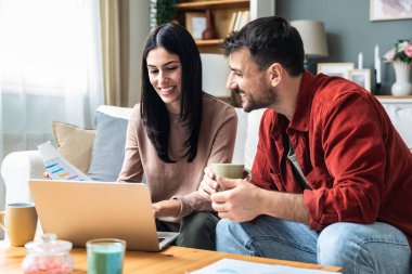 Genç iş çifti serbest çalışanlar, küçük şirket sahipleri, iş arkadaşları dizüstü bilgisayarda çalışıyor. İş adamı ve iş kadını küresel araştırma finansmanı ve fırsatları için bilgisayarı kullanıyor