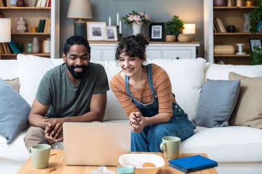 Genç serbest çalışan çift, müşteri ya da müşteriyle dizüstü bilgisayarda görüntülü görüşme yapıyor. Küçük çevrimiçi işletme sahipleri, evde çalışıyorlar, bilgisayar üzerinde çalışmak için çalışanlar işe alıyorlar..