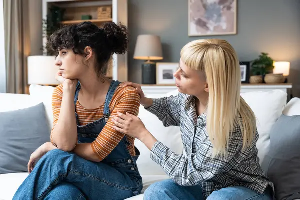 stock image Two young women friends roommates business partners owners of a small business LGBTQ+ lesbian couple arguing at home due to inappropriate spending of money and increased expenses on household bills.