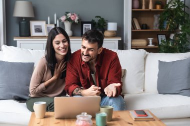 Psikoterapistleriyle evden video görüşmesi yapan genç bir çift. İletişim sorunları, ilişki sorunları ve evlilik danışmanlığı için online terapiden sonra ona yardımları için teşekkür ediyorlar.