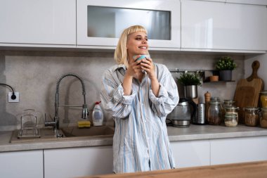 Genç, mutlu, yeni boşanmış, ya da yeni boşanmış, zehirli bir ilişkiden yeni çıkmış, mutfakta durmuş, kahve ya da çay kiralıyor, yeni başlangıçların tadını çıkarıyor ve sabah sessizliğinin tadını çıkarıyor.