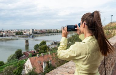 Basit bir yaşam. Seyahat ve moda konsepti. Şehir caddesinde güneş gözlüğü pozu veren turkuaz yeşil elbiseli güzel bir kadın. Yazın şirin, şık, şık bir kadın..