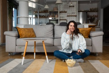 Genç, mutlu, yeni boşanmış ya da yeni boşanmış bir kadın zehirli bir ilişkiden sonra evde tek başına oturup patlamış mısır yiyor ve yeni dairesinde film ya da televizyon izliyor..