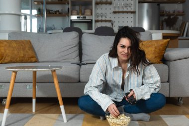 Genç, mutlu, yeni boşanmış ya da yeni boşanmış bir kadın zehirli bir ilişkiden sonra evde tek başına oturup patlamış mısır yiyor ve yeni dairesinde film ya da televizyon izliyor..