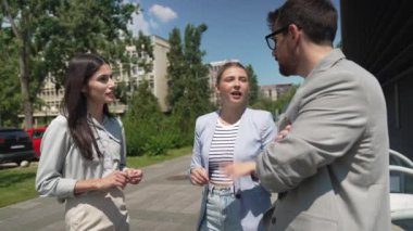 Bir grup başarılı iş adamı, işadamı ve iş kadını resmi giysiler içinde ofis binasının önünde durmuş iş hakkında tartışıyorlar. Harika mutlu gurbetçi şirket uzmanları bilgi alışverişinde bulunuyor.
