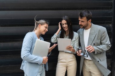 Bir grup başarılı genç iş adamı, pazarlama ve motivasyon liderleri, ofis binasının önünde durup çalışanlarla bir toplantı öncesinde danışmanlık yapıyorlar. Şirket konseptinde insan kaynakları iletişimi