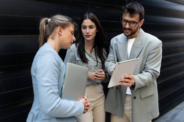 Bir grup başarılı genç iş adamı, pazarlama ve motivasyon liderleri, ofis binasının önünde durup çalışanlarla bir toplantı öncesinde danışmanlık yapıyorlar. Şirket konseptinde insan kaynakları iletişimi