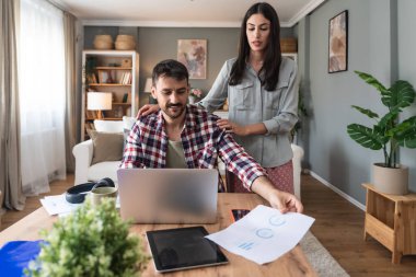 Genç içe dönük iş adamı ev ofisinden bilgisayarla çalışmaya çalışıyor. Video araması için endişeli. Kız arkadaşı da onu neşelendirip destek masajı yapmaya ve ona sarılmaya çalışıyor.