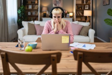 ADHD 'si olan içe dönük iş kadını ev ofisinden dizüstü bilgisayarla çalışıyor. Kalabalık ofisten ve evde bilgisayarla çalışan insanlardan kaçınan bir iş adamı..