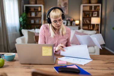ADHD 'si olan içe dönük iş kadını ev ofisinden dizüstü bilgisayarla çalışıyor. Kalabalık ofisten ve evde bilgisayarla çalışan insanlardan kaçınan bir iş adamı..
