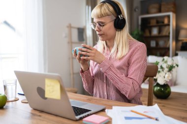 ADHD 'si olan içe dönük iş kadını ev ofisinden dizüstü bilgisayarla çalışıyor. Kalabalık ofisten ve evde bilgisayarla çalışan insanlardan kaçınan bir iş adamı..