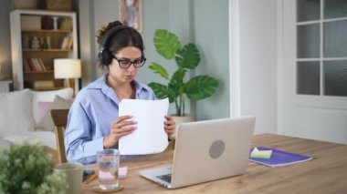 Genç mutlu, neşeli, bağımsız, serbest çalışan bir iş kadını evde oturup bilgisayarla müzik dinliyor ya da kulaklıkla podcast yapıyor. Başarılı bir iş kadını işi