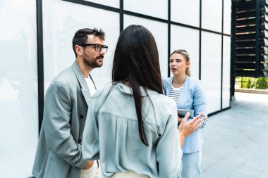 İş adamlarından oluşan bir ekip ofis binasının önünde konuşuyor. Personel toplantısı. Çalışanların motivasyon konuşması hakkında ofis çalışanlarını bilgilendirme toplantısı. İş adamı ve iş kadını fırsatları tartışıyor