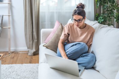 Genç işsiz kadın evde oturup kolay para ve çabuk para kazanmayı umuyor, pasif gelir ödeyen anketler için internet üzerinde çalışıyor para ile ilgili program için internet sitesinde sörf yapıyor.