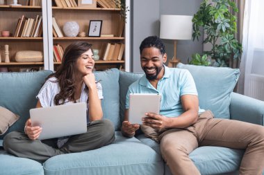 Genç mutlu iş adamları internette dijital tablet kullanarak tatil gezisi için uygun bir kamp aracı arıyorlar. İş sahipleri işlerini macera ve kamp için sattılar. Özgürlük kavramı