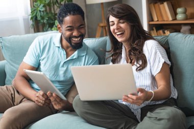 Genç mutlu iş adamları internette dijital tablet kullanarak tatil gezisi için uygun bir kamp aracı arıyorlar. İş sahipleri işlerini macera ve kamp için sattılar. Özgürlük kavramı