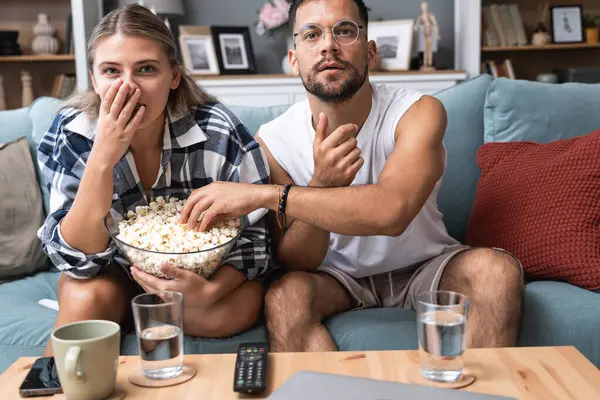 Genç bir çift, erkek ve kadın, evde kanepede oturup patlamış mısır yiyor ve korku filmi seyrediyor ya da dramatik bir spor oyunu veya dram filmi izliyor. Basit yaşam konsepti, hafta sonu aktiviteleri.