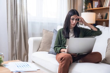 Genç işsiz kadın evde oturup kolay para ve çabuk para kazanmayı umuyor, pasif gelir ödeyen anketler için internet üzerinde çalışıyor para ile ilgili program için internet sitesinde sörf yapıyor.
