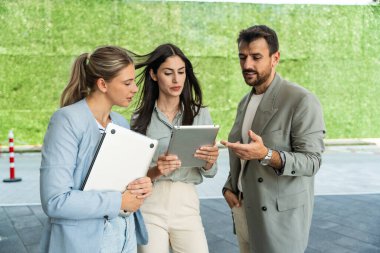 Sürdürülebilir yenilik projesi, Yeşil yenilenebilir enerji konsepti, ofis binasının dışında çalışan bir grup zeki iş adamı. Gezegeni kurtarmayı planlayan gelecekçi proje.