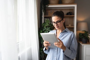 Pencereden bakan tabletli bir emlakçı. Evde çalışan genç bir iş kadını, cihaz kullanıyor. Başarılı profesyonel meslek grafik tasarımcısı kadın işe ara veriyor..