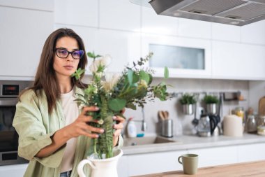 Genç, bağımsız ve güçlü bir kadın sabah mutfağında ayakta duruyor. Güzel bir dişi mutlulukla ve motivasyonla uyanır. Özgürlük ve kendini sevme yaşam tarzı kavramı.