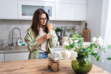 Genç, bağımsız ve güçlü bir kadın sabah mutfağında ayakta duruyor. Güzel bir dişi mutlulukla ve motivasyonla uyanır. Özgürlük ve kendini sevme yaşam tarzı kavramı.