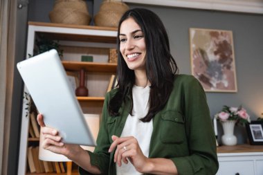 Pencereden bakan tabletli bir emlakçı. Evde çalışan genç bir iş kadını, cihaz kullanıyor. Başarılı profesyonel meslek grafik tasarımcısı kadın işe ara veriyor..