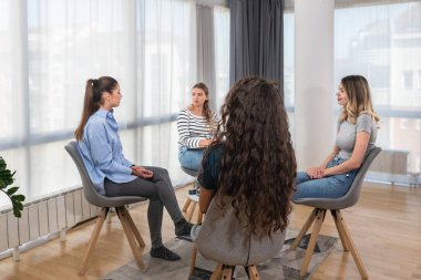 Bir grup kadın oturup konuşuyor, iş ve başarıyı tartışıyorlar. Serbest çalışanların takım çalışması, birlikte fikirler ve çözümler geliştiriyoruz..