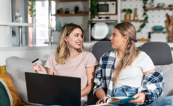 stock image Two women roommates, small company owners, working at home on laptop computer. Internet teamwork work, startup company developers, designers and online digital marketing experts.