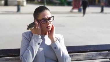 İş kadını 20 'li yaşlardaki açık havada hoparlör kullanarak akıllı telefondan sesli mesaj dinliyor. Beyaz iş kadını profesyonel CEO şehirdeki sesli mesaj hoparlörünü dinliyor