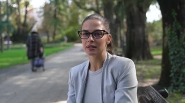 Şehir merkezindeki parkta oturan, medyaya röportaj veren, yakışıklı, profesyonel bir kadın. POV kadın kültür ve seyahat uzmanı televizyon veya vlog hakkında konuşuyor.