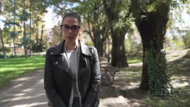 Şehir merkezindeki parkta oturan, medyaya röportaj veren, yakışıklı, profesyonel bir kadın. POV kadın kültür ve seyahat uzmanı televizyon veya vlog hakkında konuşuyor.