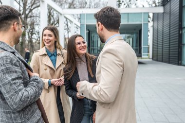 Bir grup genç iş adamı borsa ve değişim uzmanları, modern bilim, finans ve ekonomi liderleri ofis binasının önünde duruyorlar. Personel üyeleri iş adamı ve iş kadınıyla tanışıyor