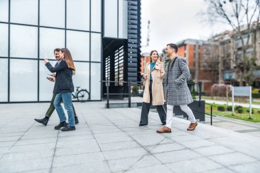 Bir grup genç iş adamı borsa ve değişim uzmanları, modern bilim, finans ve ekonomi liderleri ofis binasının önünde duruyorlar. Personel üyeleri iş adamı ve iş kadınıyla tanışıyor